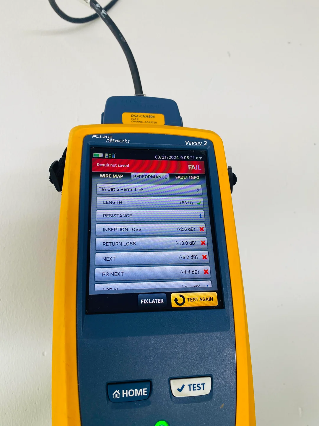 Mãos operando equipamento de certificação conectado a patch panel em rack